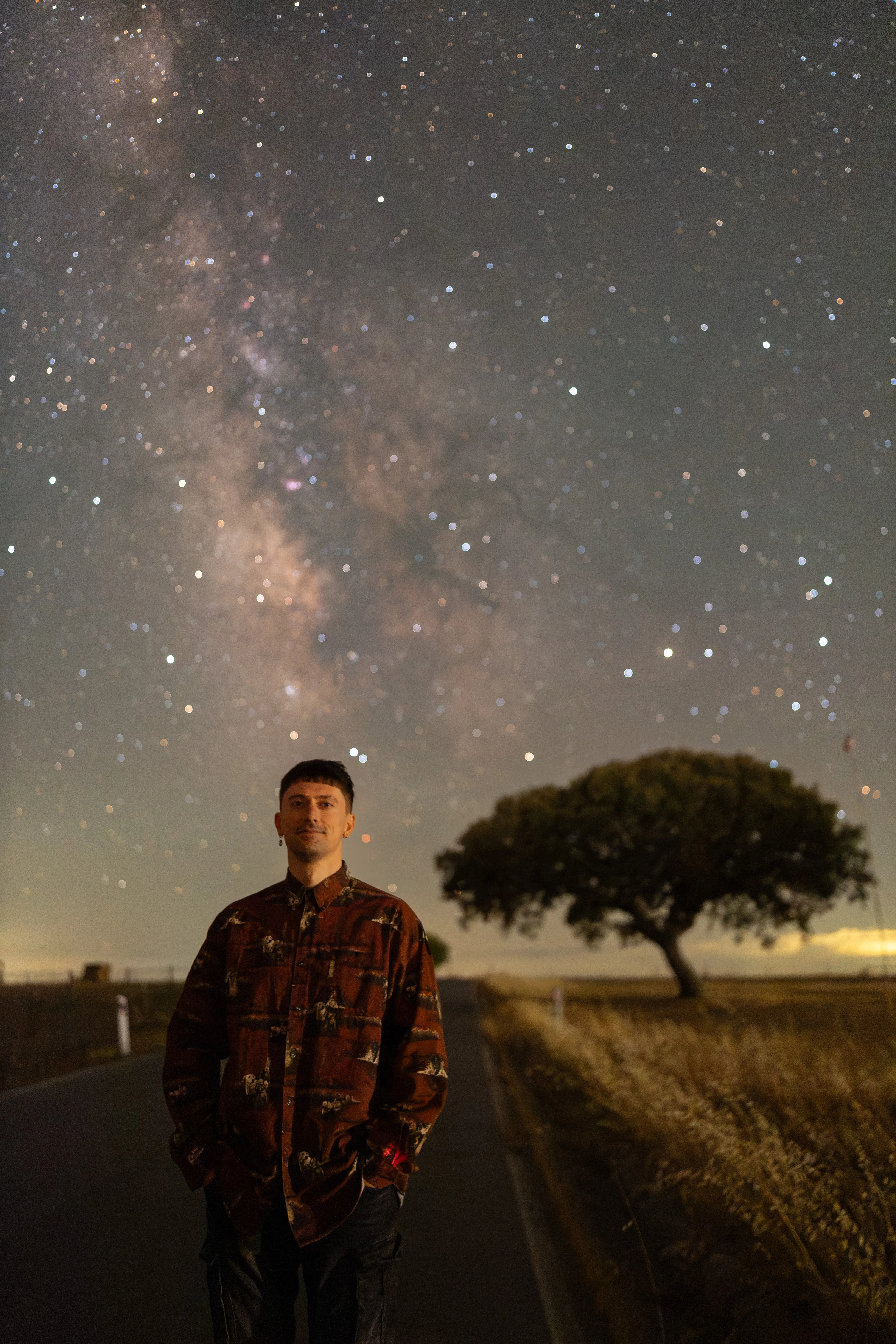 Retrato de um homem sob a Via Láctea, junto a um azinheira, no observatório do Astromidnight