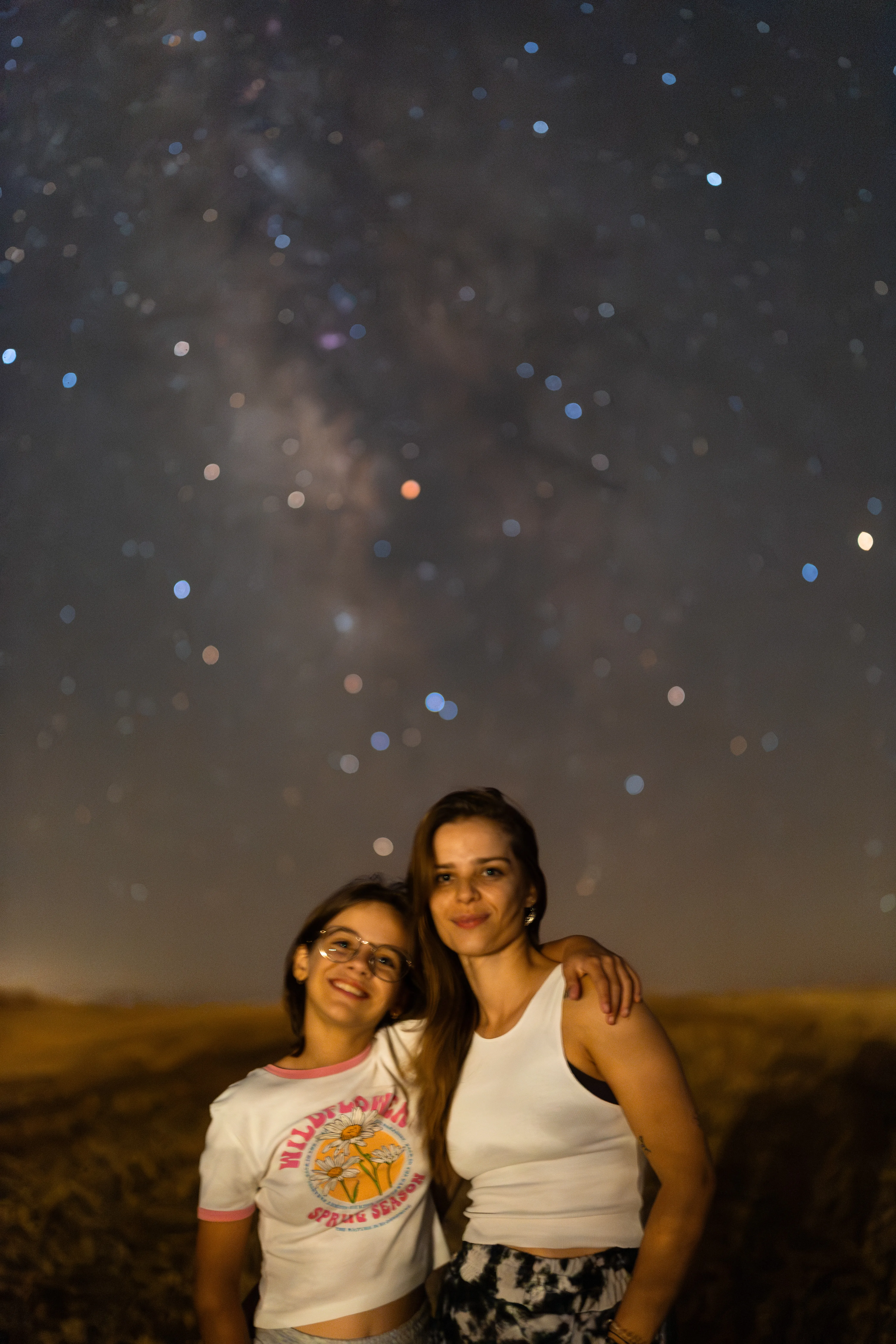 Duas pessoas em retrato sob um céu estrelado